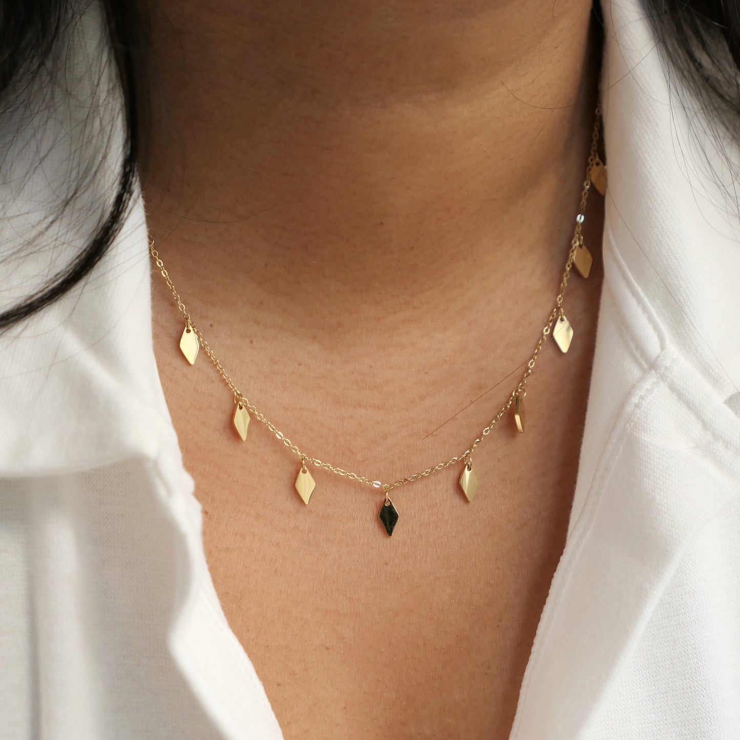 Women in white shirt wearing a shiny tassel necklace